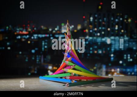 Abstract Christmas Tree from Pencils and City Lights Background Stock Photo