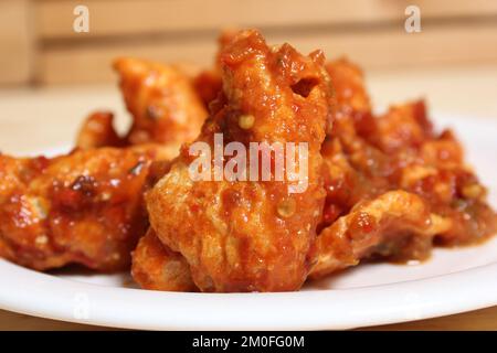 Fried Pork Skins With Red Salsa on Wooden Table in Rustic Kitchen Stock Photo