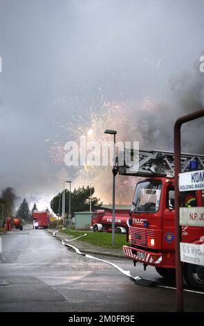 Fire erupted in two containers on the grounds of a firework plant, a fireman was cought by the explosion and his body is still in the fire and at least 10 people were injured in Kolding, Denmark. Anyone living within 500 meters of the N.P. Johnsens fireworks factory was evacuated to a nearby school. This morning it is still burning and three more containers with fireworks are in danger to explode. Stock Photo