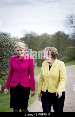 German Chancellor Angela Merkel (R) and Danish Prime Minister Helle Thorning-Schmidt walk through the park of Marienborg near Copenhagen, Denmark, 28 April 2015. Stock Photo