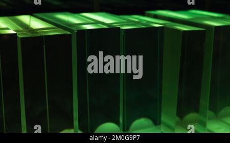 Solid glass blocks stand in a row under colorful illumination, abstract ...