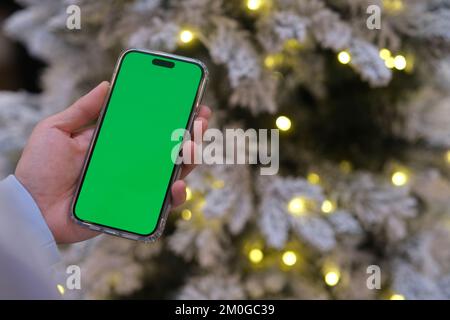hand holding green screen smartphone with Christmas eve at night Stock Photo