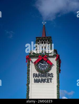 Los Angeles, CA, USA – December 5, 2022: A large Christmas wreath decorates the Farmers Market clock tower at the Grove shopping center in Los Angeles Stock Photo