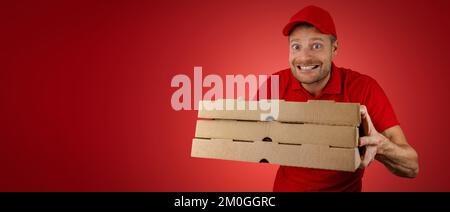 funny delivery man with pizza boxes on red background. banner with copy space Stock Photo