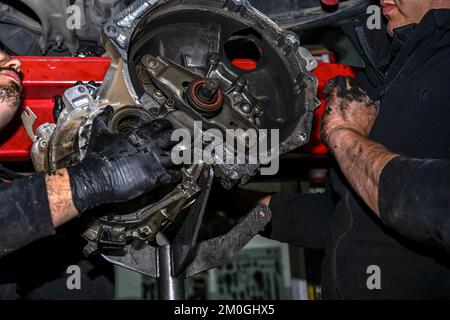 Hands of a mechanic removing the clutch disc from a vehicle Stock Photo
