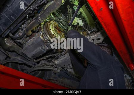 Hands of a mechanic removing the clutch disc from a vehicle Stock Photo