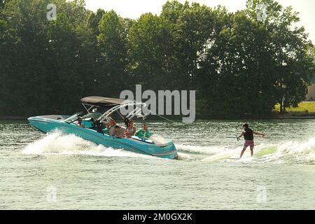 Young boy water skiing with family on a lake in Virginia, USA Stock Photo