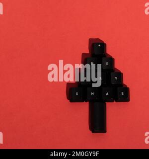 Christmas tree made of black keyboard keys with merry Xmas writing. Christmas minimal concept. Stock Photo