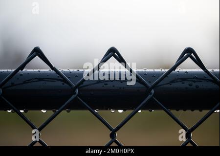 A macro of a metallic fence with raindrops on it Stock Photo