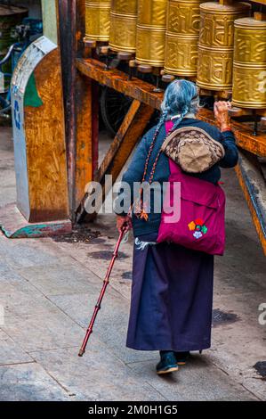 Old tibetan pilgrim walking on the Barkhor, Lhasa, Tibet, Asia Stock Photo