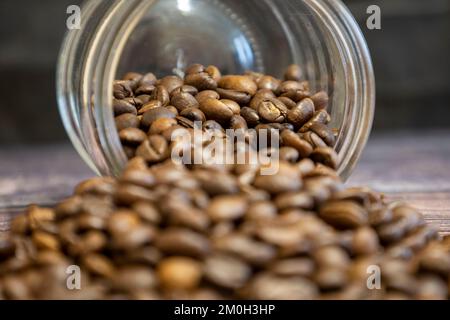 Spilled coffee beans from a glass jar. Selective focus. Stock Photo