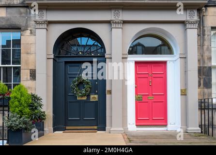 Edinburgh New Town, Scotland, UK, 6th December 2022. Christmas door wreaths and decorations: residents in the Georgian townhouses in the New Town are well-known for their splendid decorations. Pictured: two front doors with fanlights and a Christmas wreath. Credit: Sally Anderson/Alamy Live News Stock Photo