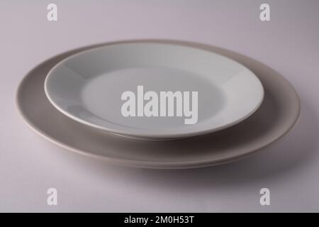 photo of two plates standing on top of each other on a white background Stock Photo