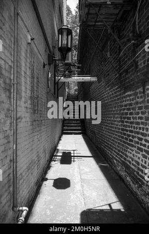 A vertical grayscale of a narrow alley, and old brick walls, in Fareham ...