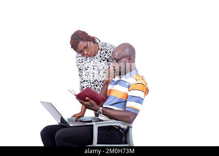 portrait of two serious businesspeople checking notes together in notebook using laptop. Stock Photo