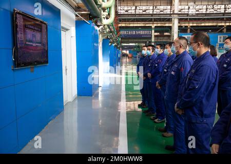 (221206) -- HARBIN, Dec. 6, 2022 (Xinhua) -- Staff members watch the live broadcast memorial meeting for Comrade Jiang Zemin at a factory of Harbin Electric Machinery Company Ltd. of Harbin Electric Corporation in Harbin, northeast China's Heilongjiang Province, Dec. 6, 2022. A memorial meeting for Jiang Zemin, who passed away on Nov. 30 at the age of 96, was held Tuesday morning in the Great Hall of the People in Beijing. The meeting was held by the Communist Party of China (CPC) Central Committee, the Standing Committee of the National People's Congress (NPC), the State Council, the Nati Stock Photo