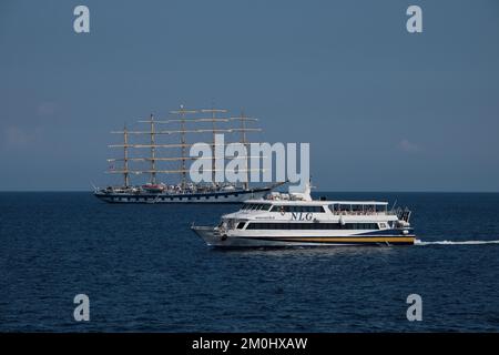 The Royal Clipper tall ship seen off the Amalfi Coast close to Positano Italy passed by a NLG Capri jet. Stock Photo