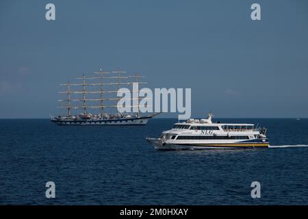 The Royal Clipper tall ship seen off the Amalfi Coast close to Positano Italy passed by a NLG Capri jet. Stock Photo