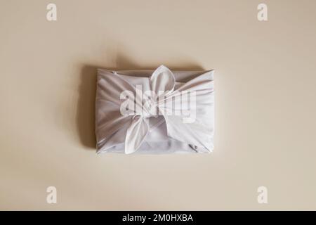 Furoshiki is a Japanese gift wrapping fabric that is traditionally used in Asia. environmental gifts. Gifts on a light background. Stock Photo