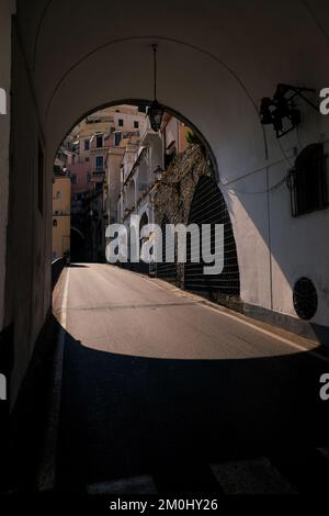 Via Matteo camera road tunnel in the Amalfi Town Italy with the sunlight shining in through the archway with the traditional houses behind. Stock Photo