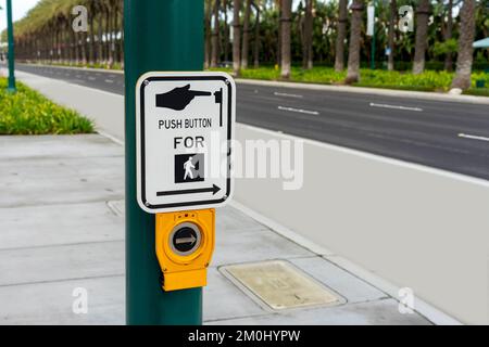 Push Button For Crossing sign on a green post Stock Photo