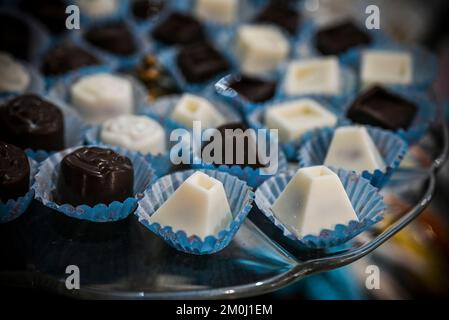 Assorted white and dark chocolate pralines arranged on a glass plate Stock Photo