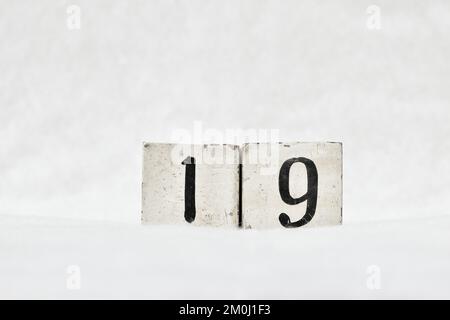 19 vintage wooden block calendar number on white snow background, copy space for text. Save the date for birthday, anniversary, special day or occasio Stock Photo