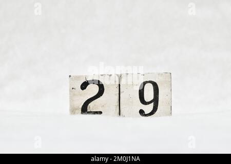 29 vintage wooden block calendar number on white snow background, copy space for text. Save the date for birthday, anniversary, special day or occasio Stock Photo