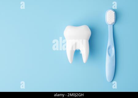 Toy tooth and toothbrush on blue background, flat lay Stock Photo