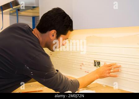 Construction - Installation of Backsplash in Kitchen Remodel Stock Photo