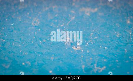 Frozen droplets. Close up of a drop. Raining on a blue swimming pool water surface.  Stock Photo