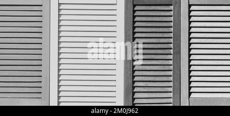 Part of modern interior with grey patterned texture of wooden black and white shutters, casements or blinds background. Stock Photo