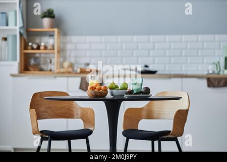 Background image of minimal kitchen interior with elegant wooden chairs and table set, copy space Stock Photo