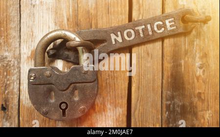 Security concept. There is a lock on the door on the metal part of which it is written - NOTICE Stock Photo