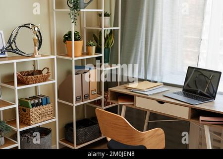 Background image of cozy home office workplace with wooden details and metal shelves with decor items, copy space Stock Photo