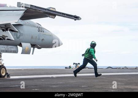 Philippine Sea. 25th Nov, 2022. Aviation Boatswains Mate (Equipment) 3rd Class Shanastie Hublanco, from Naalehu, Hawaii, clears the runway prior to the launch of an F/A-18E Super Hornet, attached to the Eagles of Strike Fighter Squadron (VFA) 115, on the flight deck of the U.S. Navys only forward-deployed aircraft carrier, USS Ronald Reagan (CVN 76), in the Philippine Sea, November. 25. The Eagles conduct carrier-based air strikes and strike force escort missions, as well as ship, battle group, and intelligence collection operations. Ronald Reagan, the flagship of Carrier Strike Group 5, Stock Photo