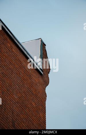Upper corner of irregular red brick wall Stock Photo