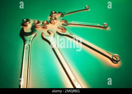 Spanners and Nuts on Green Background Stock Photo