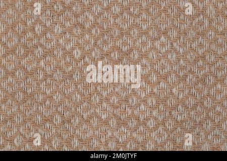 Brown and white geometric woolen fabric throw background, machine woven pattern texture. Light bedcover closeup Stock Photo