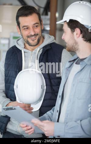 2 male engineers with clipboard looking at clipbord Stock Photo