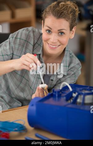 female technician wiring cables into chocolate box Stock Photo