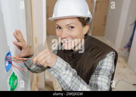 female electrician fixing socket electricity problem Stock Photo