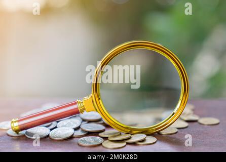 Magnifying Glass With pile of coins isolate on white background