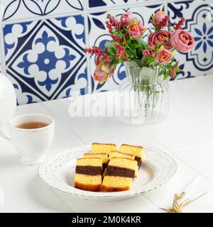 Malaysian Dish Kek Lapis Sarawak or Sarawak Layered Cake on WHite Table, Served with Tea Stock Photo