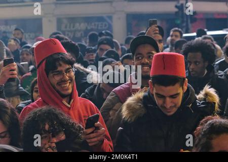 London, UK. 6th December, 2022. Overjoyed Morocco football fans meet once again at Piccadilly Circus after the national team defeated Spain in a 3-0 penalty shoot-out, eliminating the side from the tournament.  It is the first time the Moroccan team, also known as the 'Atlas Lions' has reached the quarter-finals in the World Cup, where they will face Portugal next.  Credit: Eleventh Hour Photography/Alamy Live News Stock Photo