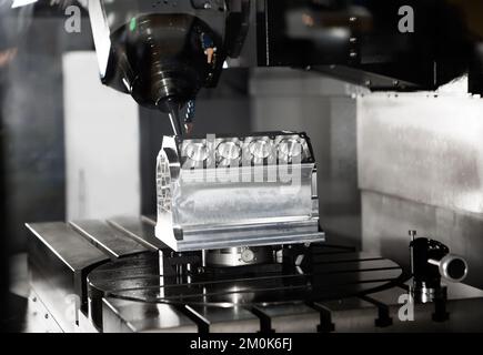Modern industry high precision CNC milling machine cutting engine part. CNC programming code. Industrial metalworking manufacturing. Stock Photo