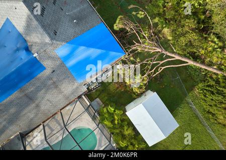 Hurricane Ian damaged house rooftop covered with protective plastic