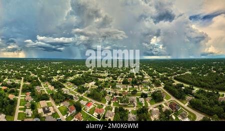 Landscape of dark ominous clouds forming on stormy sky during heavy thunderstorm over rural town area Stock Photo