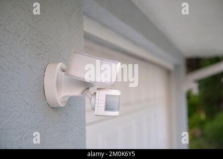 Motion sensor with light detector mounted on exterior wall of private house as part of security system Stock Photo