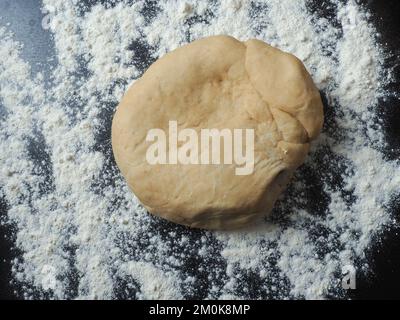 Fresh yeast dough with flour on a kitchen countertop Stock Photo